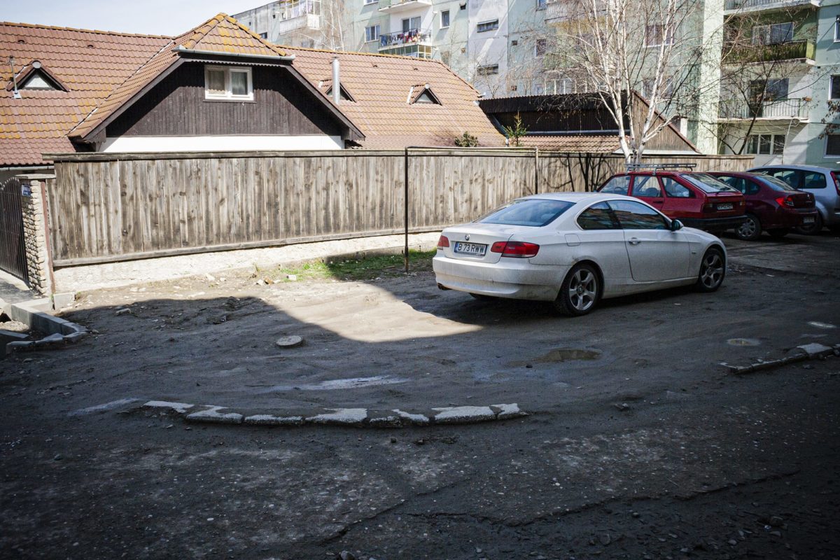A white BMW parked in an old playground
