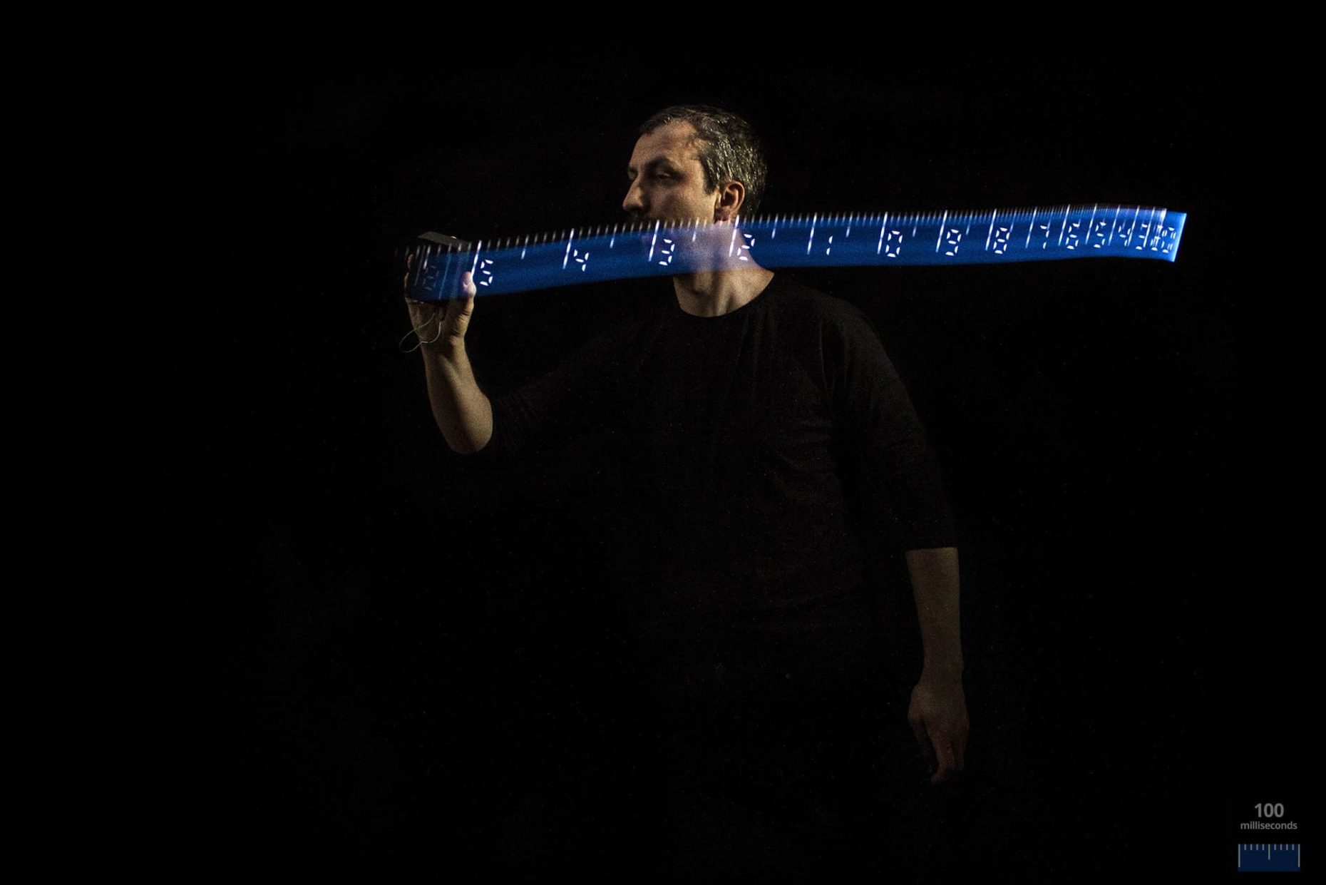 Long exposure photo of a person light painting with a custom made light painting device