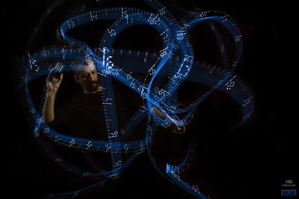 Long exposure photo of a person light painting with a custom made light painting device