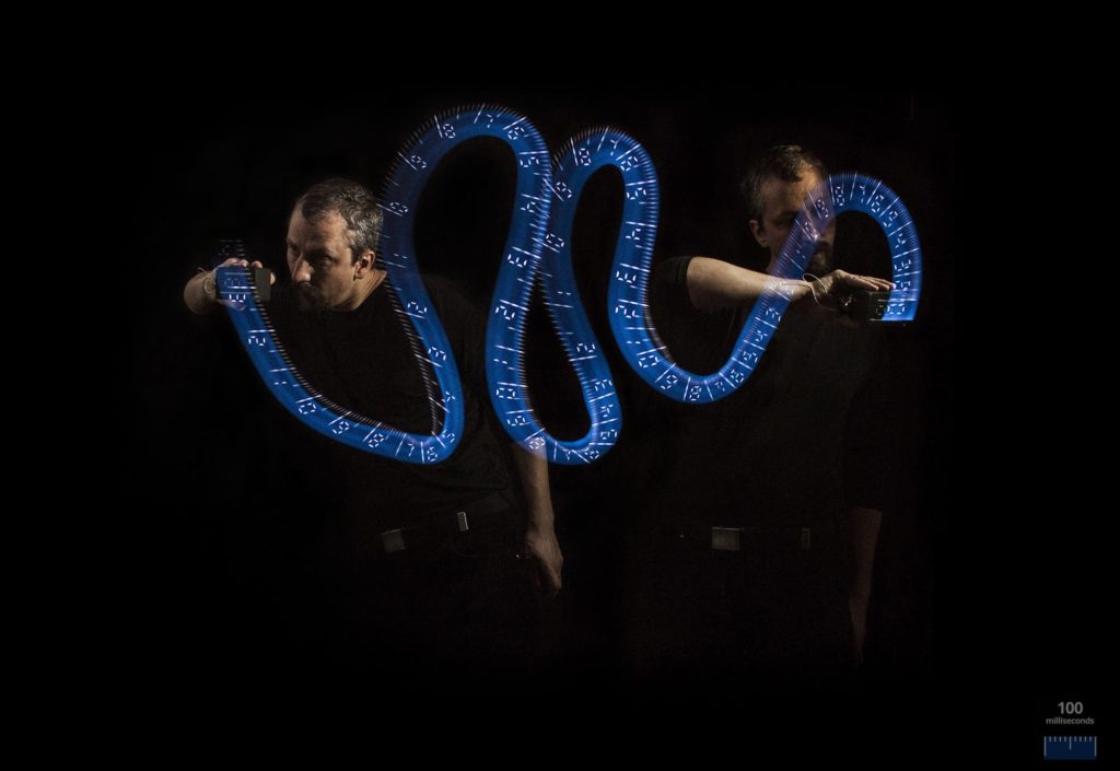 Long exposure photo of a person light painting with a custom made light painting device