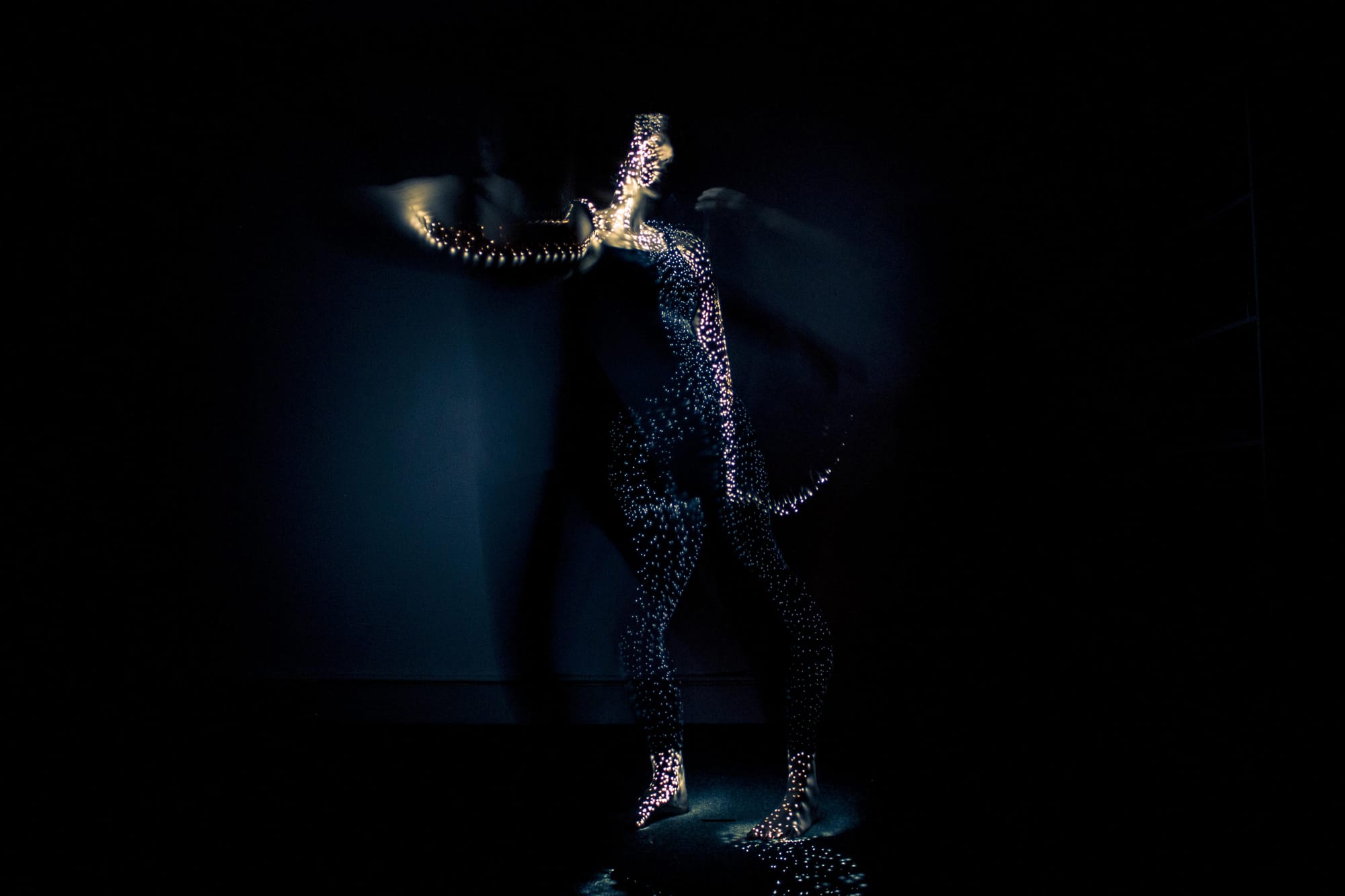 Long exposure photo of a person painting herself with a lightbrush