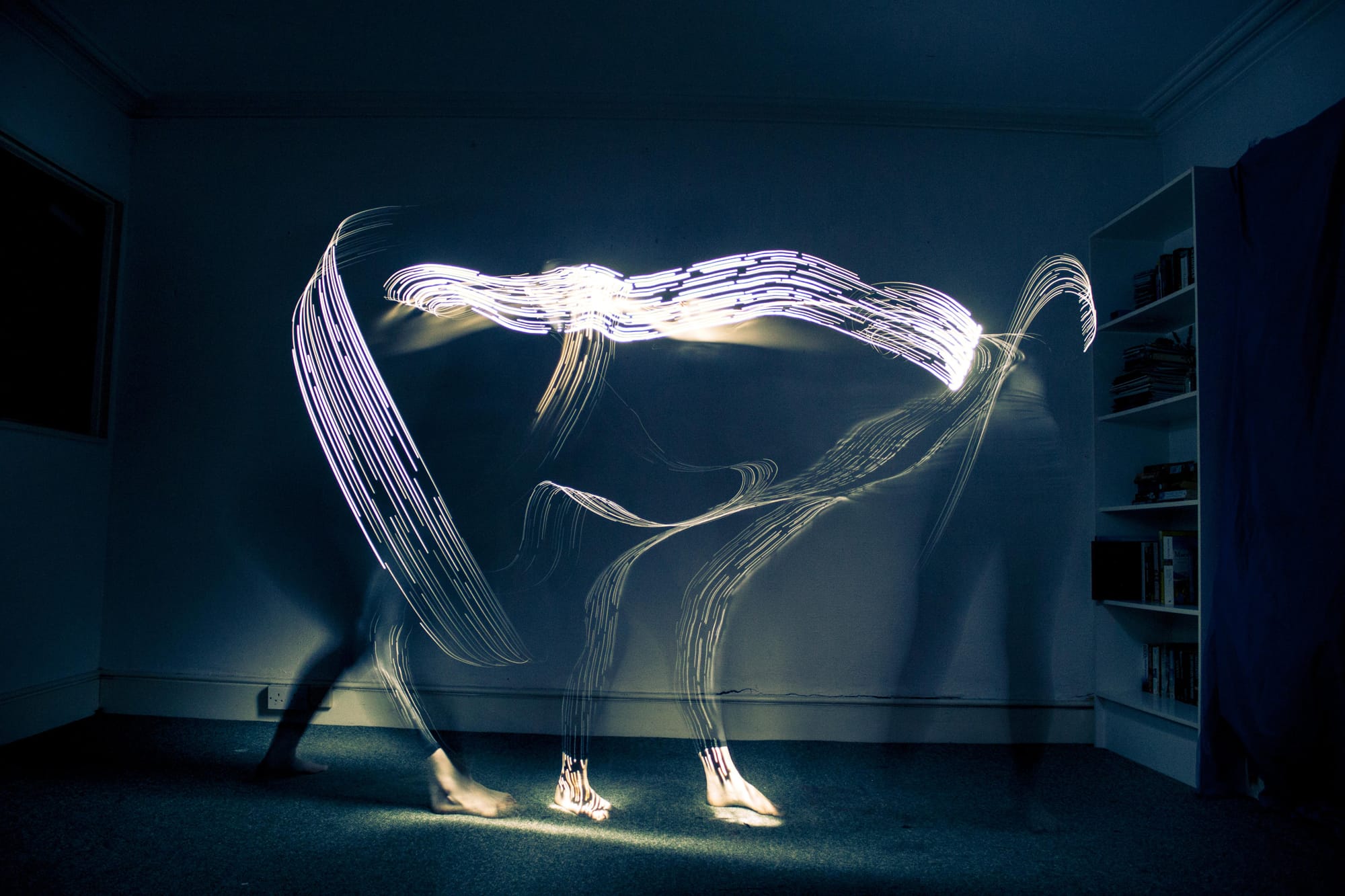 Long exposure photo of a person painting herself with a lightbrush